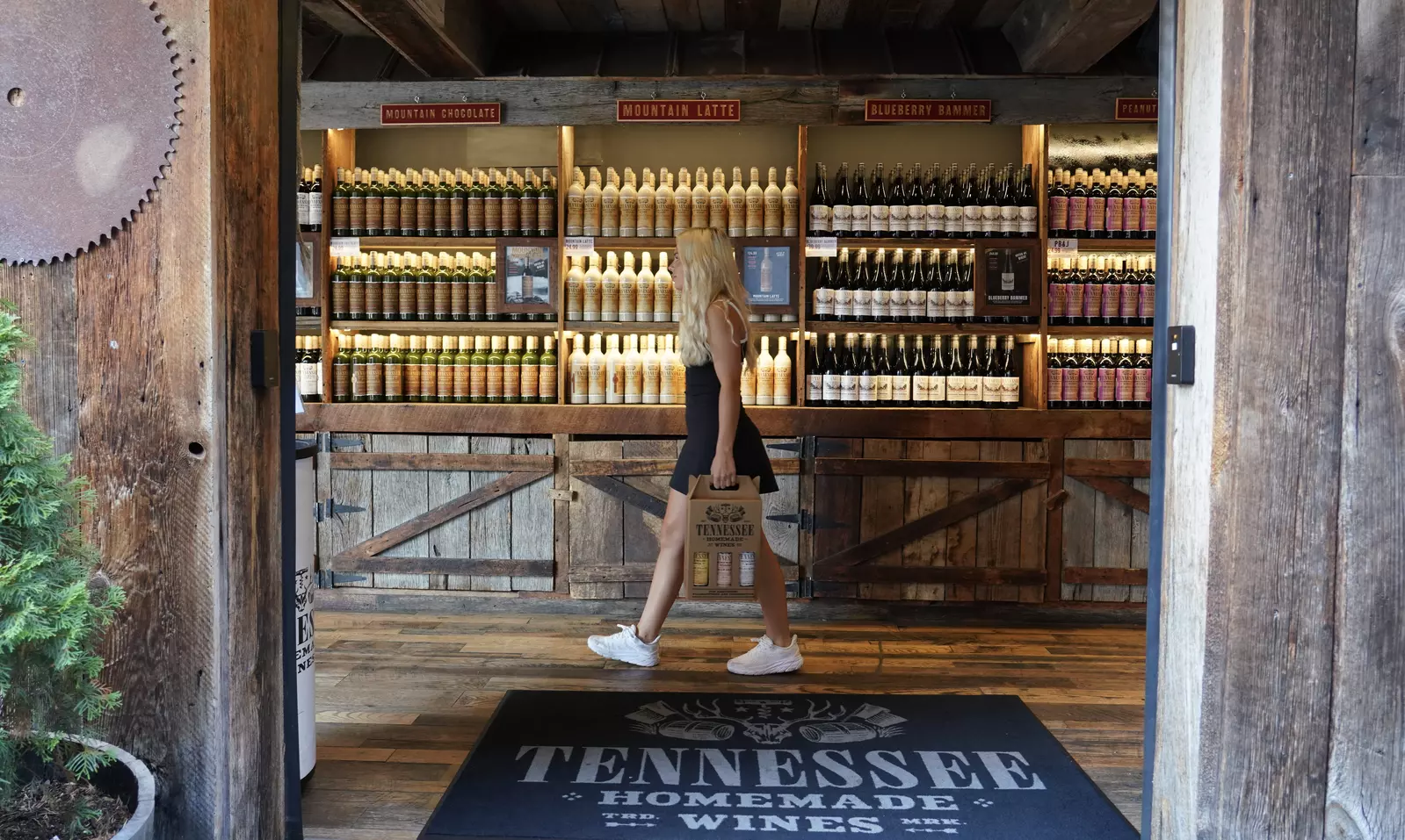 girl walking in Tennessee Homemade Wines with case of wine